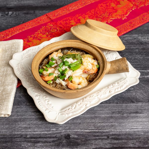 Shrimp and crab meat with glass noodles, green onions, and cilantro in a clay pot.